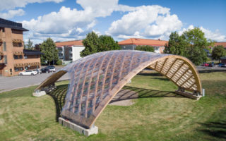 A timber and polycarbonate deployable grid shell