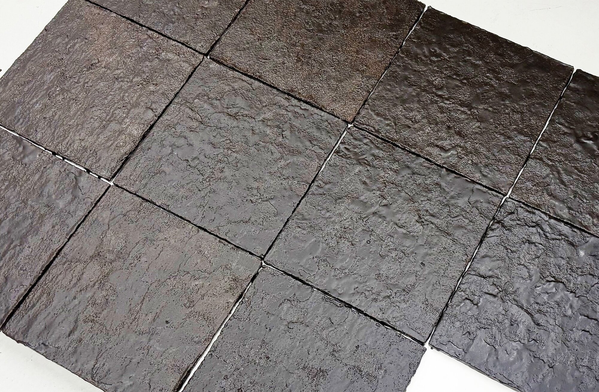 Dark brown handmade tiles made from coffee grounds laid in a grid