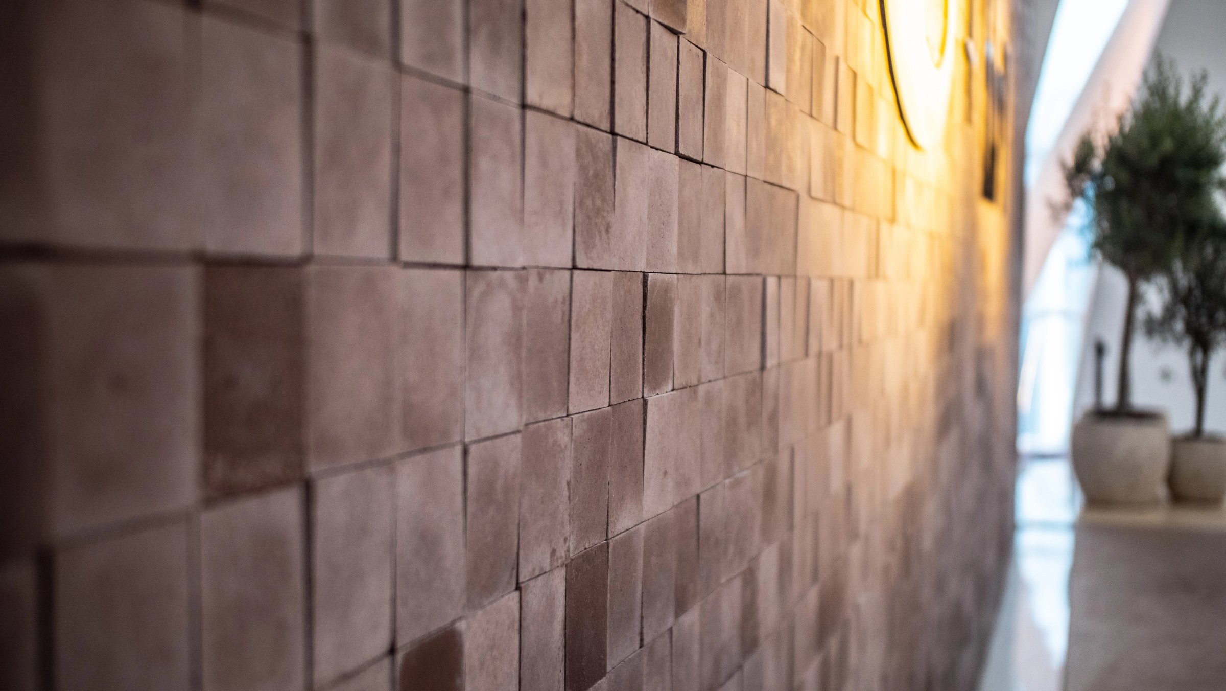 Wall of small brown tiles with a slightly uneven, handmade surface