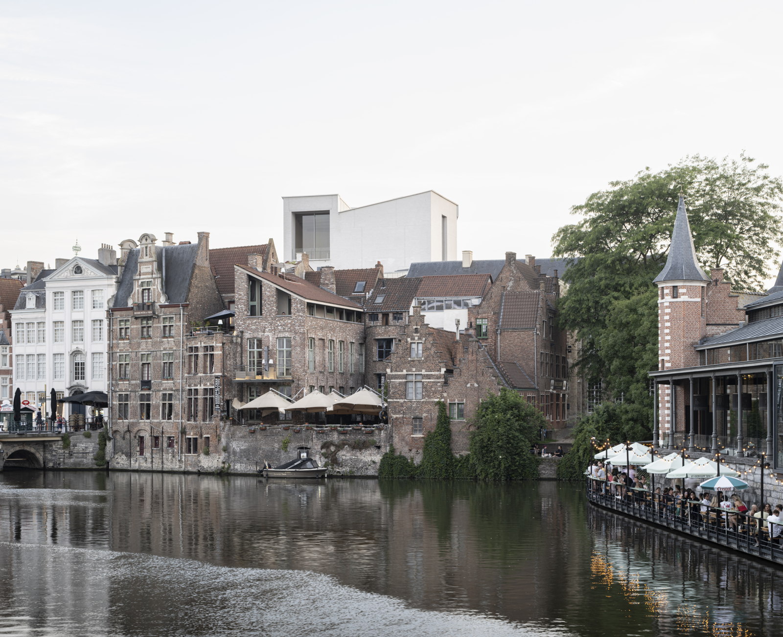 View from the Zuivelbrug across the river to the white volume of the new museum wing above the old rooftops
