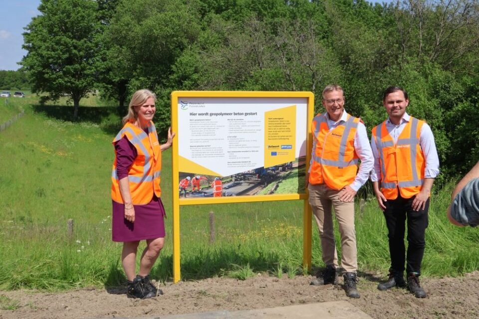 Yellow information board next to a cycle path in a green verge