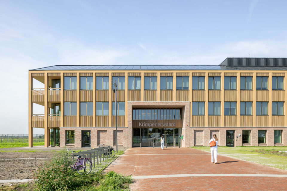Three-storey town hall with timber and brick facade, a brick-paved forecourt and bicycles