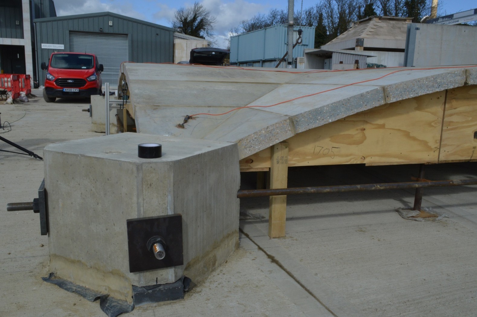 Precast concrete capital with a steel tie rod next to timber formwork