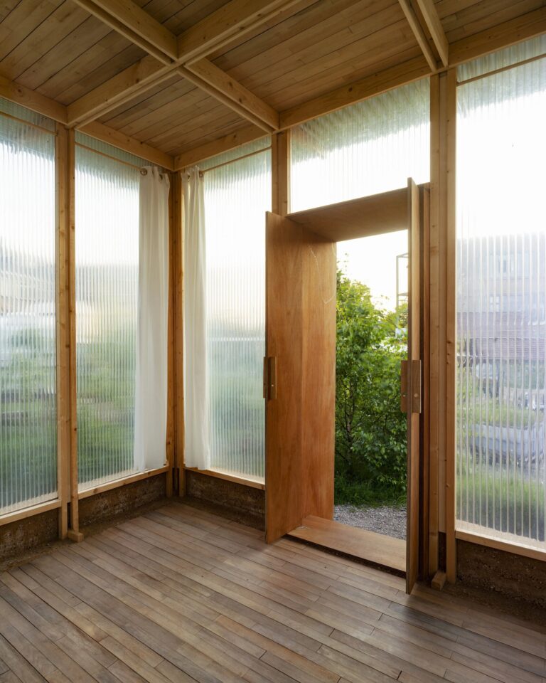 Interior with timber floor, wooden ceiling ribs and corrugated translucent walls
