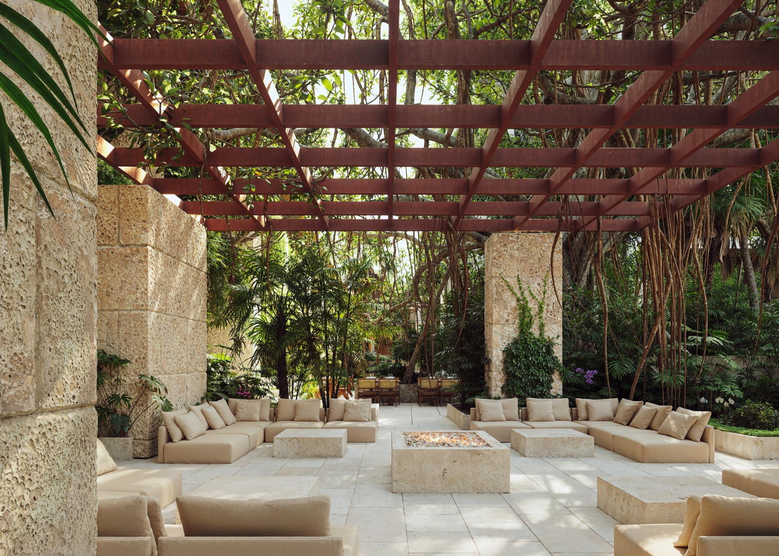 Rendering of a shaded courtyard with coral stone walls, stone benches and a steel pergola